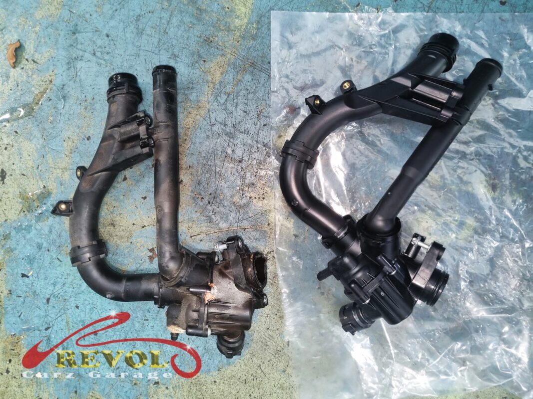 The old thermostat housing assembly (left, corroded at the seal) beside the new Mercedes-spec unit (right).