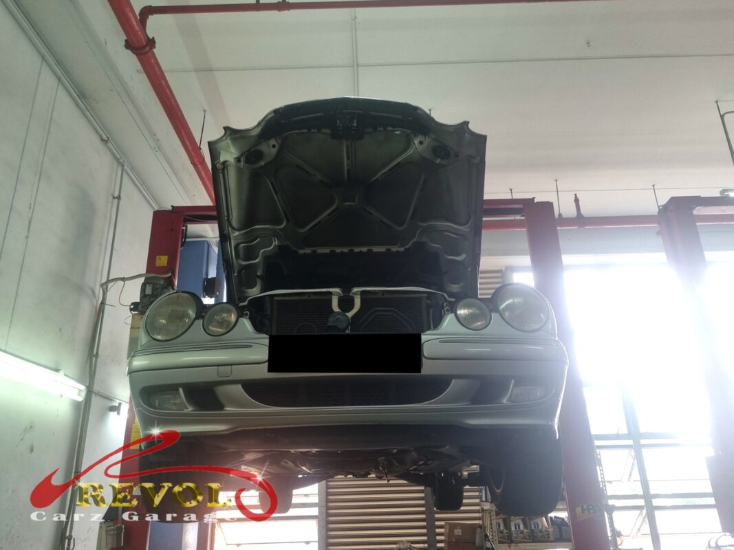 The E200 up on the lift, hood open, in to chase the oil drip from the gearbox area.