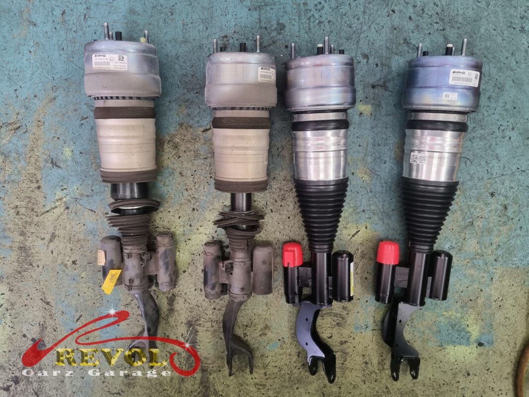 The old AIRMATIC air struts (left, bellows perished) beside the new AMG-spec replacements (right).