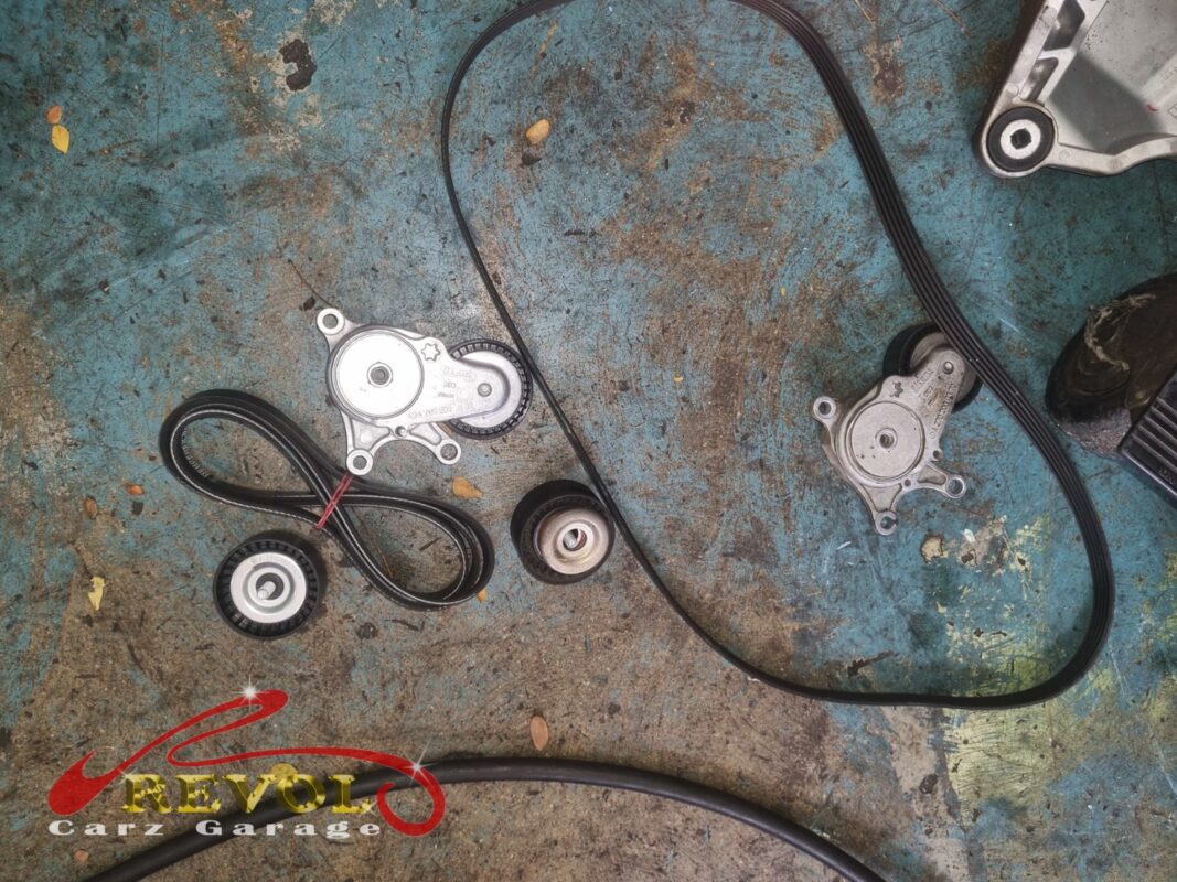 The old serpentine belt and tensioner (left) beside the new Mercedes-spec belt, tensioner and idler (right), done with the alternator.