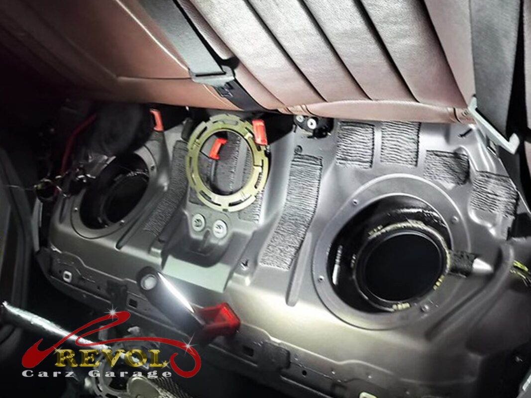The rear floor opened up, both fuel-tank access hatches exposed for the pump job.