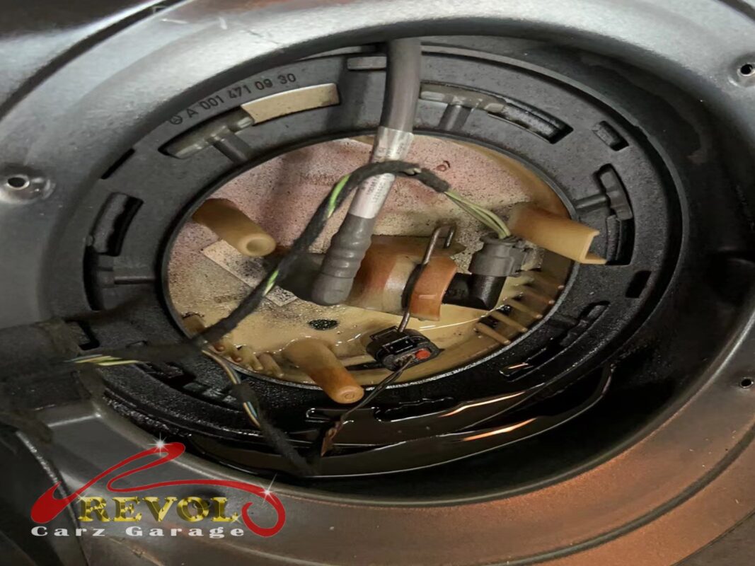 The in-tank fuel pump and filter module exposed through the access hatch under the rear seat.