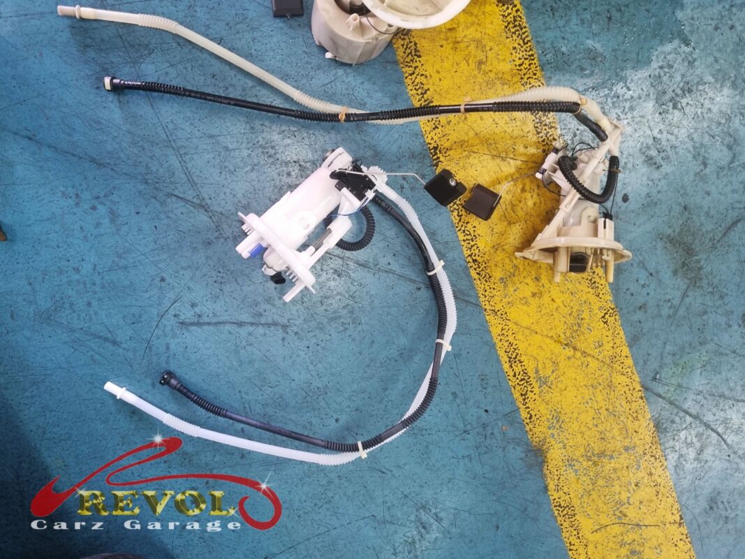 Old and new fuel pump assemblies laid out with their crossover hoses before the swap.
