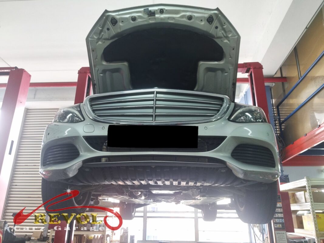 The C180 up on the two-post lift, hood open, in for the warm aircon and the grinding noise.