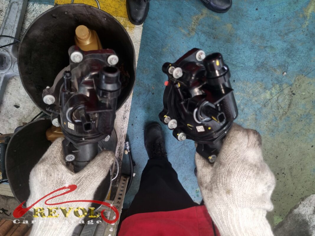 The old thermostat housing (left) beside the new Mercedes-spec module (right).