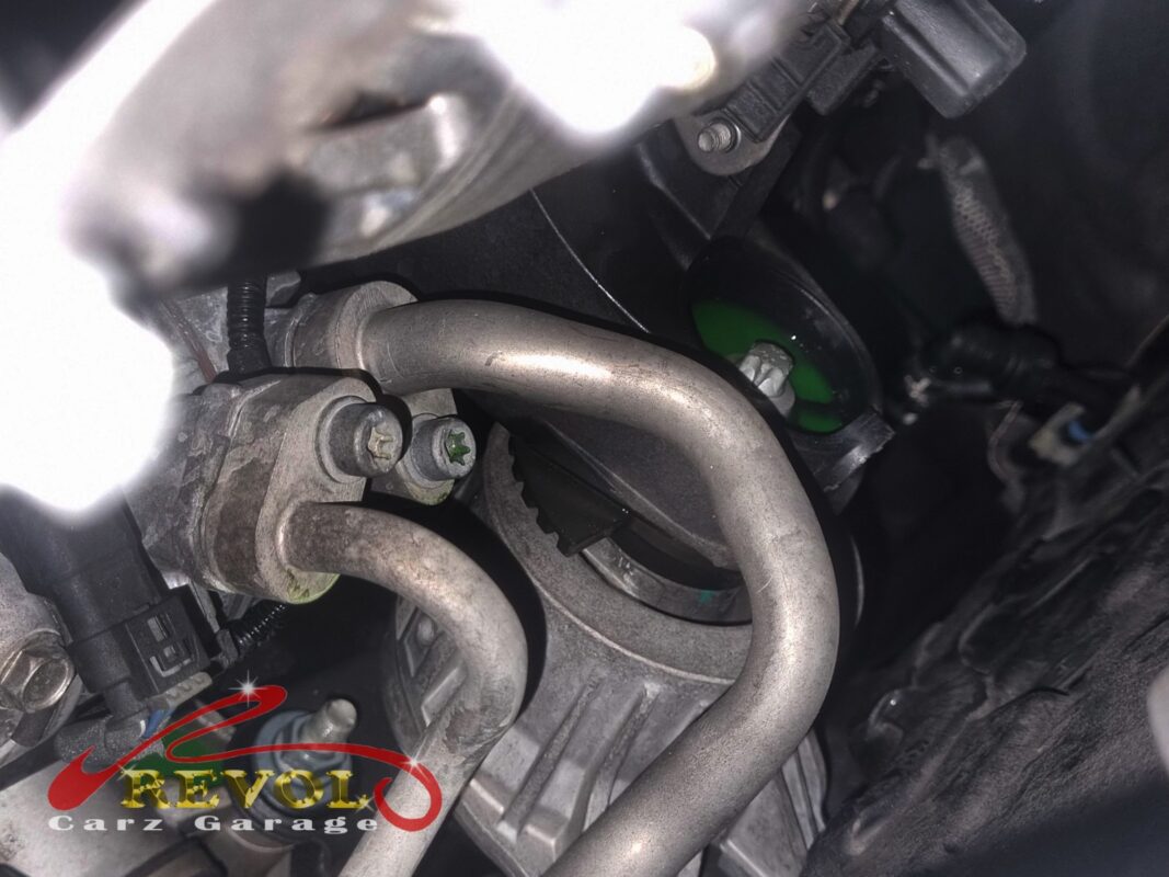 Green coolant residue at a pipe joint in the engine bay, the trace of the leak.