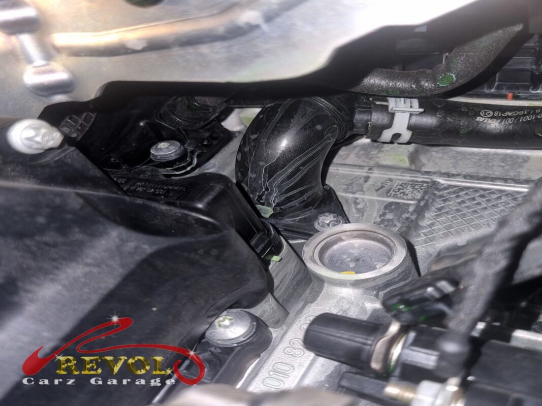 Coolant residue building on the plastic coolant pipework at the front of the engine.