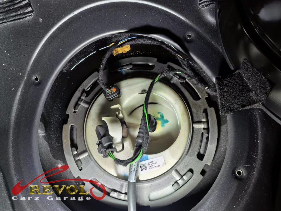 The in-tank fuel pump module exposed through the access hatch under the rear seat.