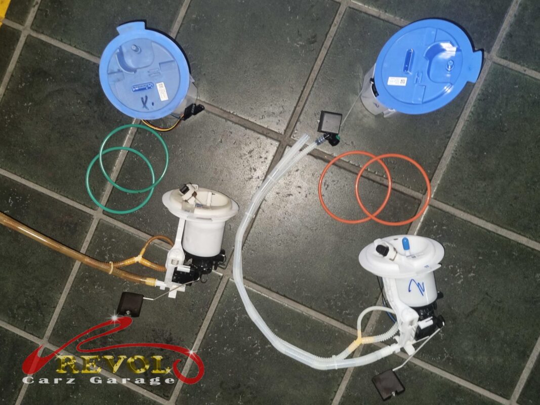 Old and new fuel pump assemblies and tank parts laid out before the swap.