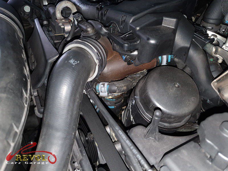 The old cracked plastic thermostat housing removed from the engine.