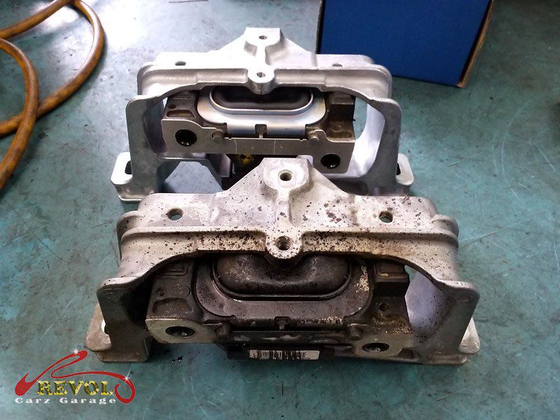 The worn engine mount with cracked and sunken rubber on the Mercedes-Benz.