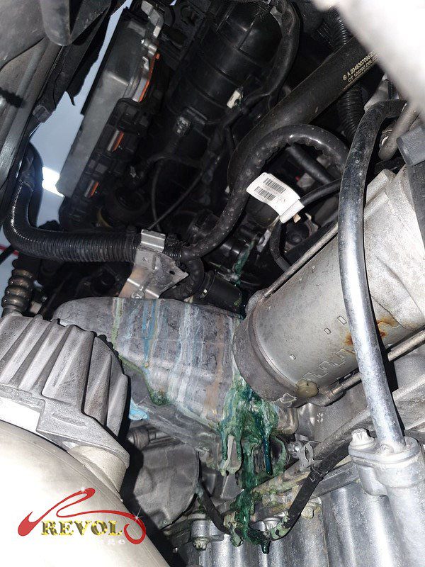 The old cracked plastic thermostat module removed from the engine.