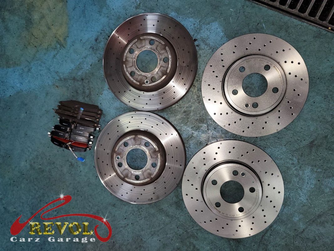The old front discs removed alongside the new genuine set.