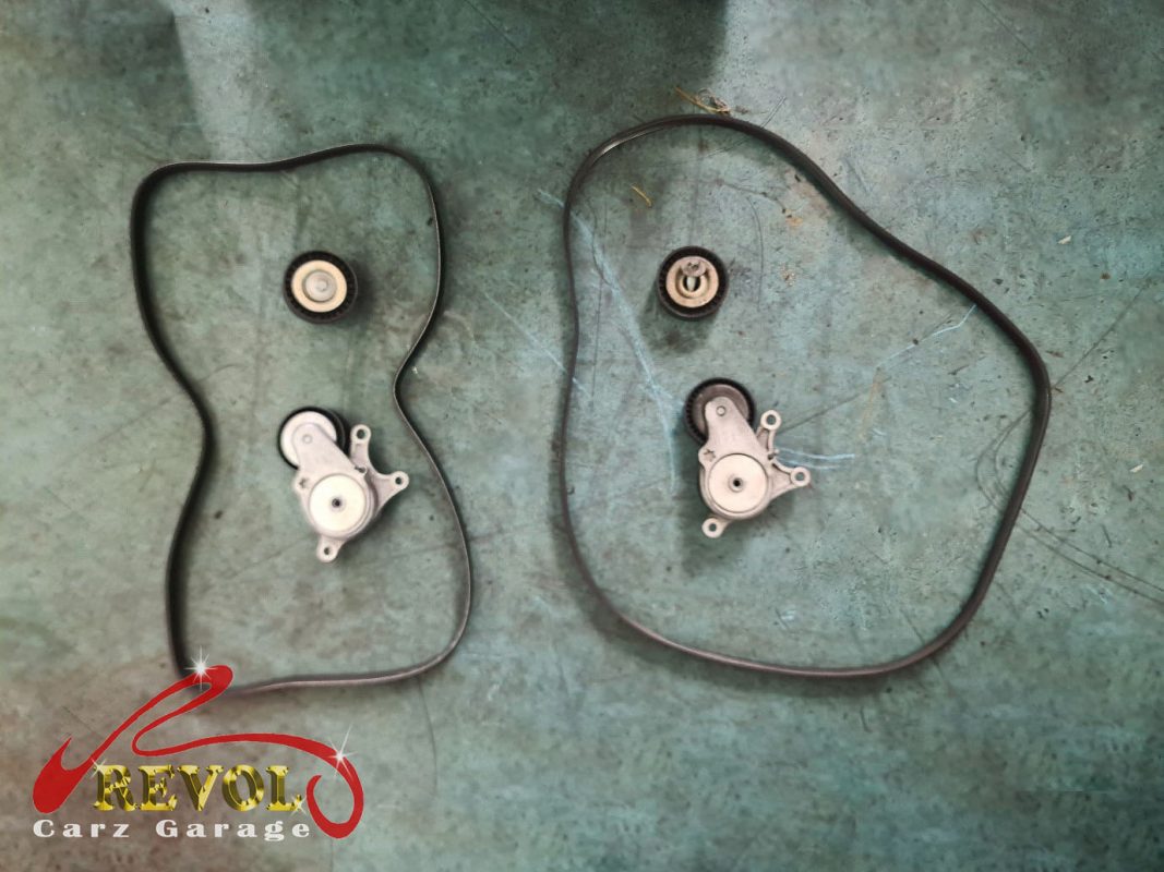 The old tensioner removed, its pulley bearing rough.