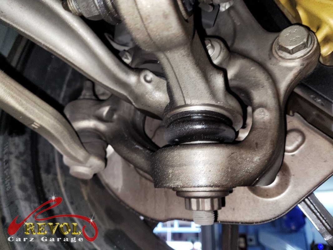 Both old front lower control arms removed alongside the new pair.
