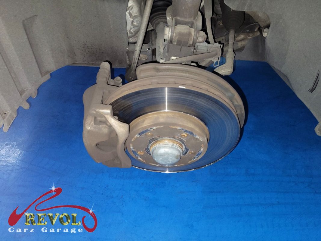 The worn front pads and scored disc on the Mercedes-Benz B180, the wear sensor ground through.