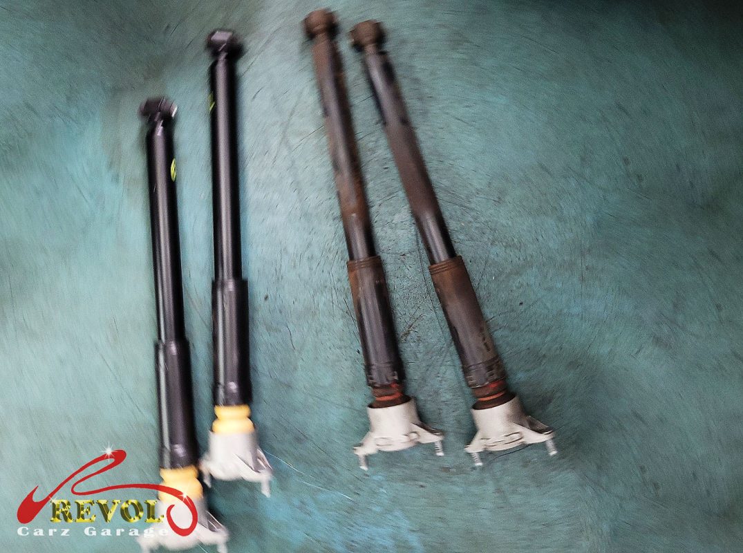 The old front struts removed alongside the new pair.