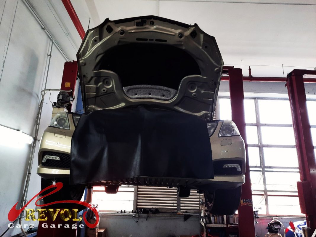 The puddle of reddish transmission fluid traced to the gearbox pan on the Mercedes-Benz E250.