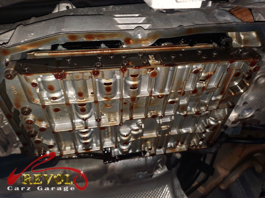 The transmission pan dropped showing the pan-and-filter assembly and the leaking gasket.