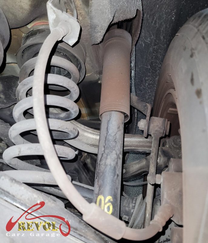 The old front struts removed alongside the new pair.