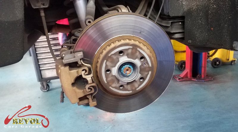 The old front discs removed alongside the new genuine set.