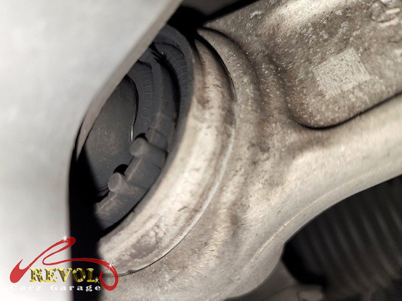 The worn front lower control arm with a cracked bushing on the Mercedes-Benz E250.