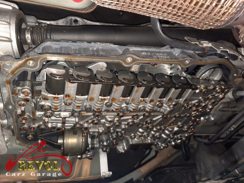 The old transmission pan dropped showing the pan-and-filter assembly.
