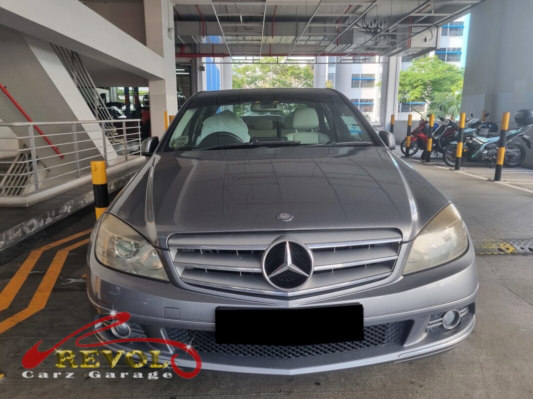 Mercedes-Benz C180 on the workshop lift for fan belt set replacement.