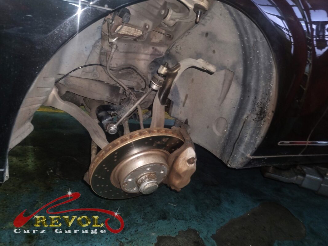 The S300L's front corner under the car, the suspension and air strut exposed for inspection.