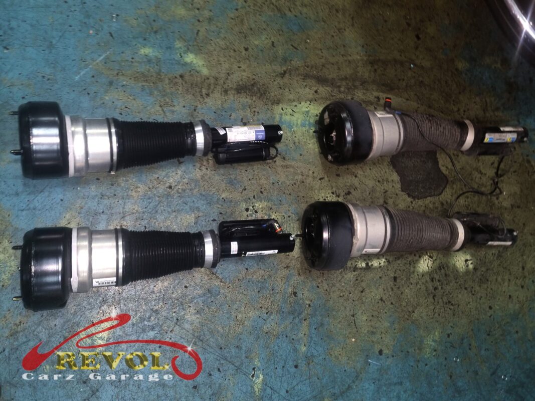 The old AIRMATIC air struts (right, bellows perished) beside the new Bilstein replacements (left).