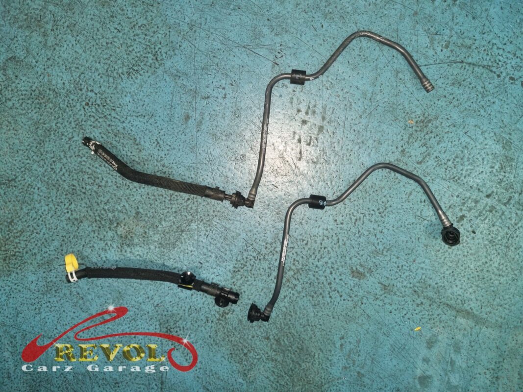 The old coolant hose (top) beside the new Mercedes-spec replacement (bottom).