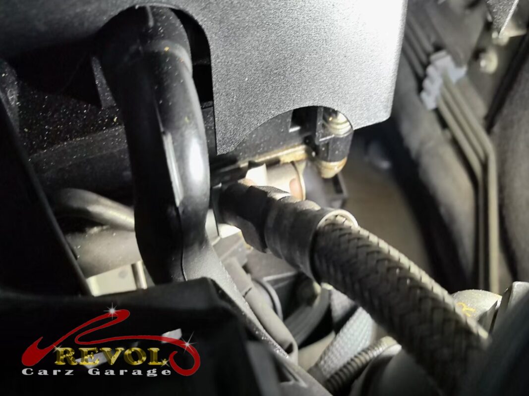 The valve cover area in the engine bay, oil traces along the edge.