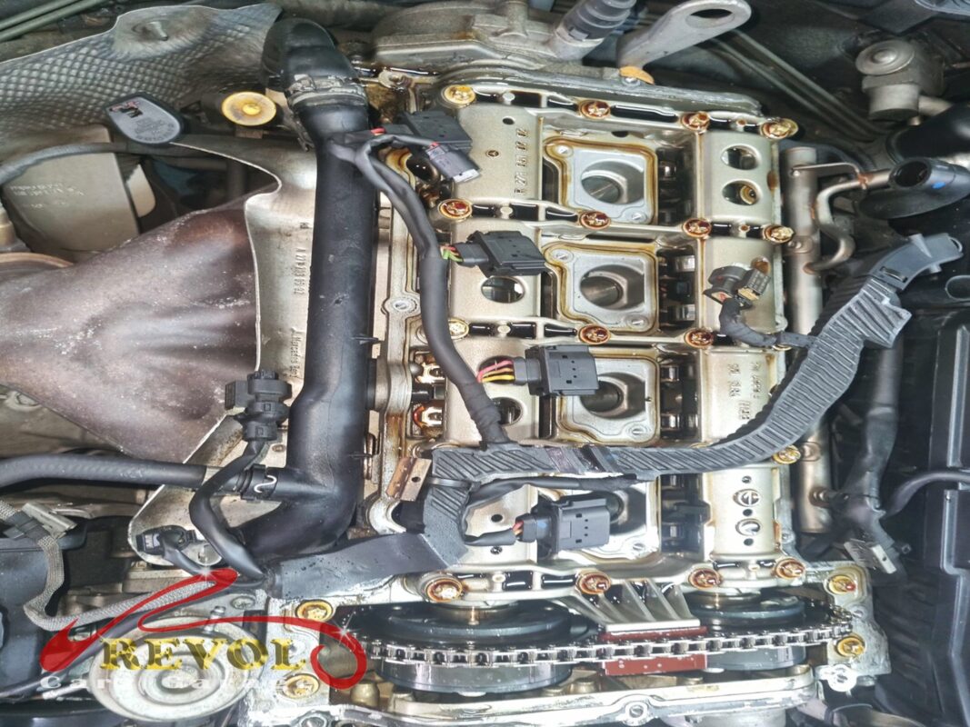 The cam cover off, the camshafts and timing chain exposed across the head.