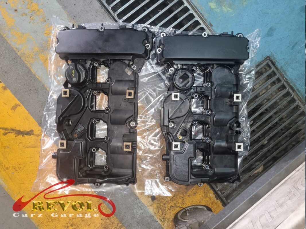 The old valve cover (right) beside the new Mercedes-spec replacement (left, in its wrap).