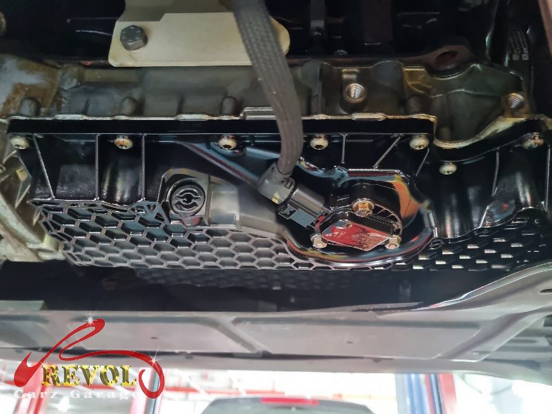 The sump pan removed showing the old gasket and the oil level sensor.