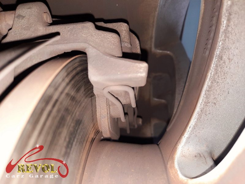 The worn front pads and scored disc on the Volkswagen Golf.