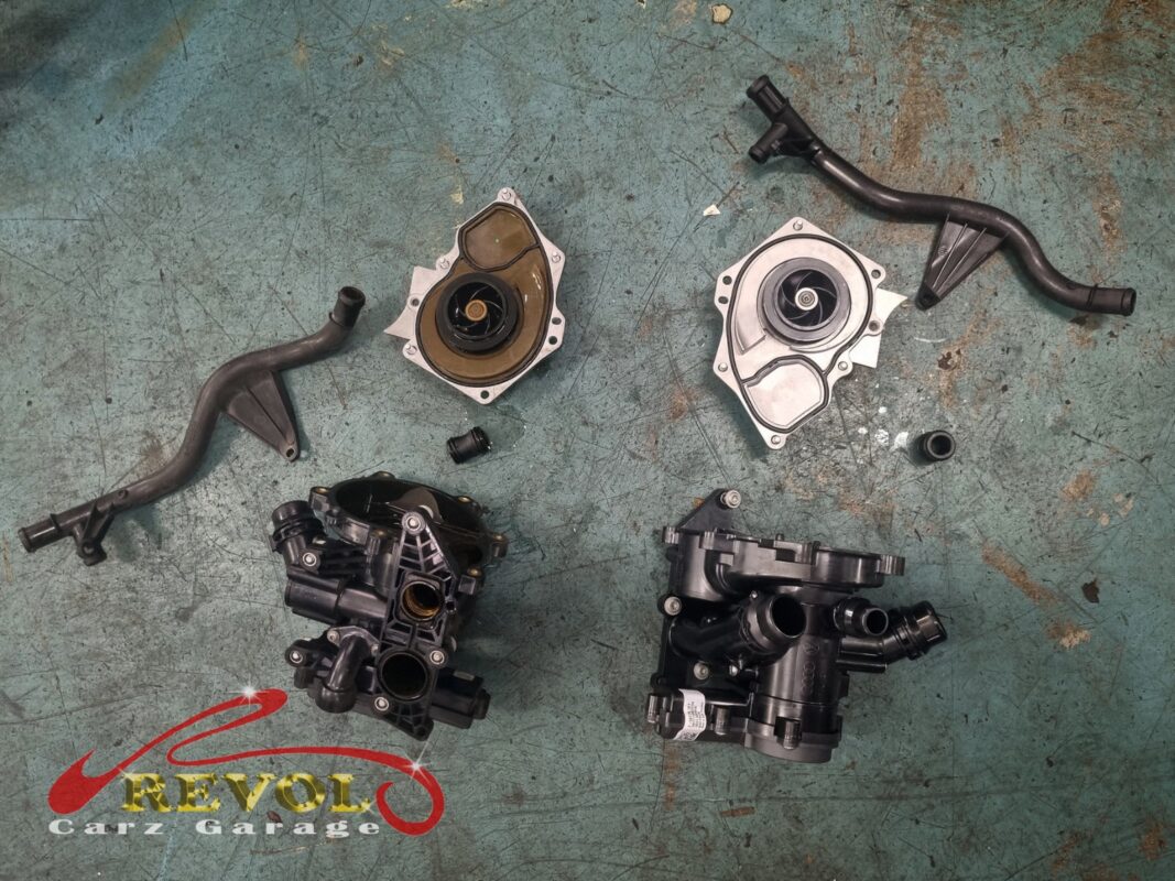 The old coolant pump removed beside the new VW-spec replacement, with a fresh seal.