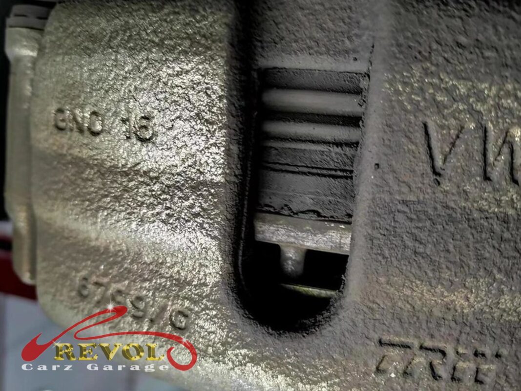 The worn front brake pads on the Volkswagen Tiguan, down to the indicator.