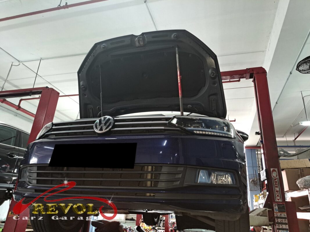 The Touran up on the two-post lift, hood open, in for the warm aircon and the grinding noise.