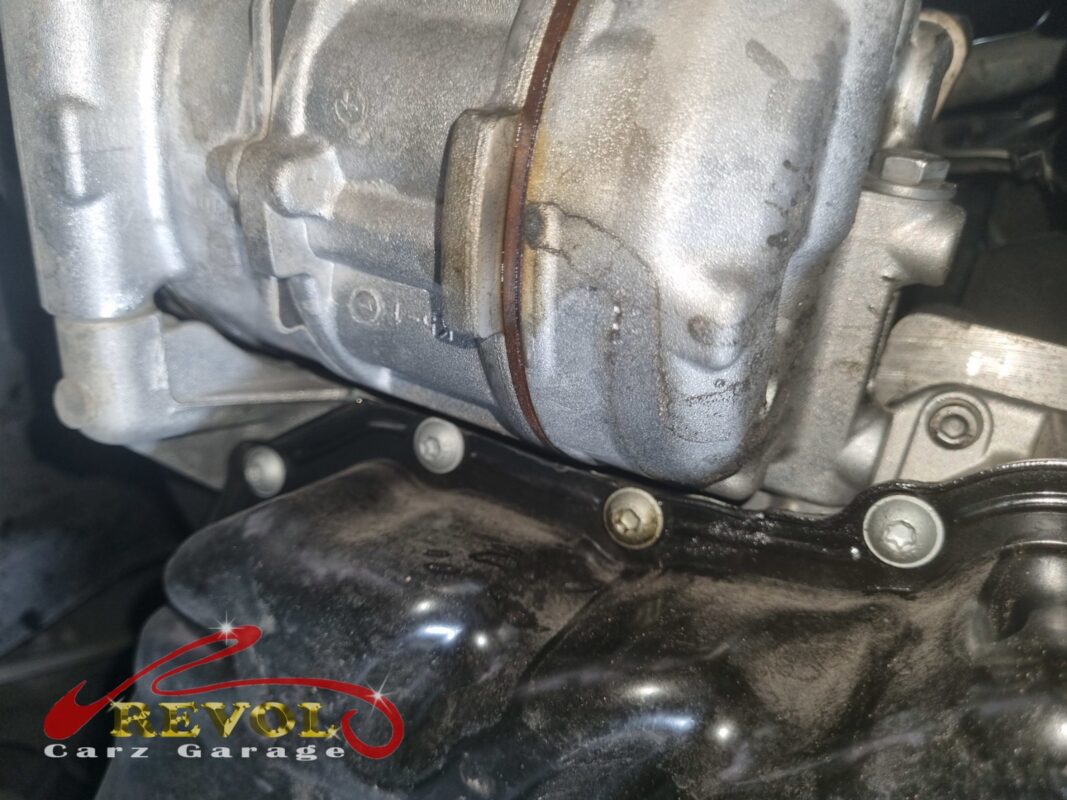The AC compressor in place on the engine, the drive belt around its clutch pulley.