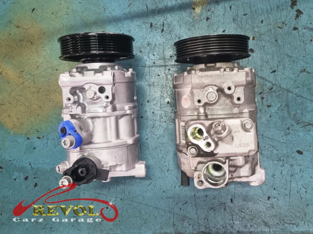 The old AC compressor (right, grimy) beside the new VAG-spec replacement (left).