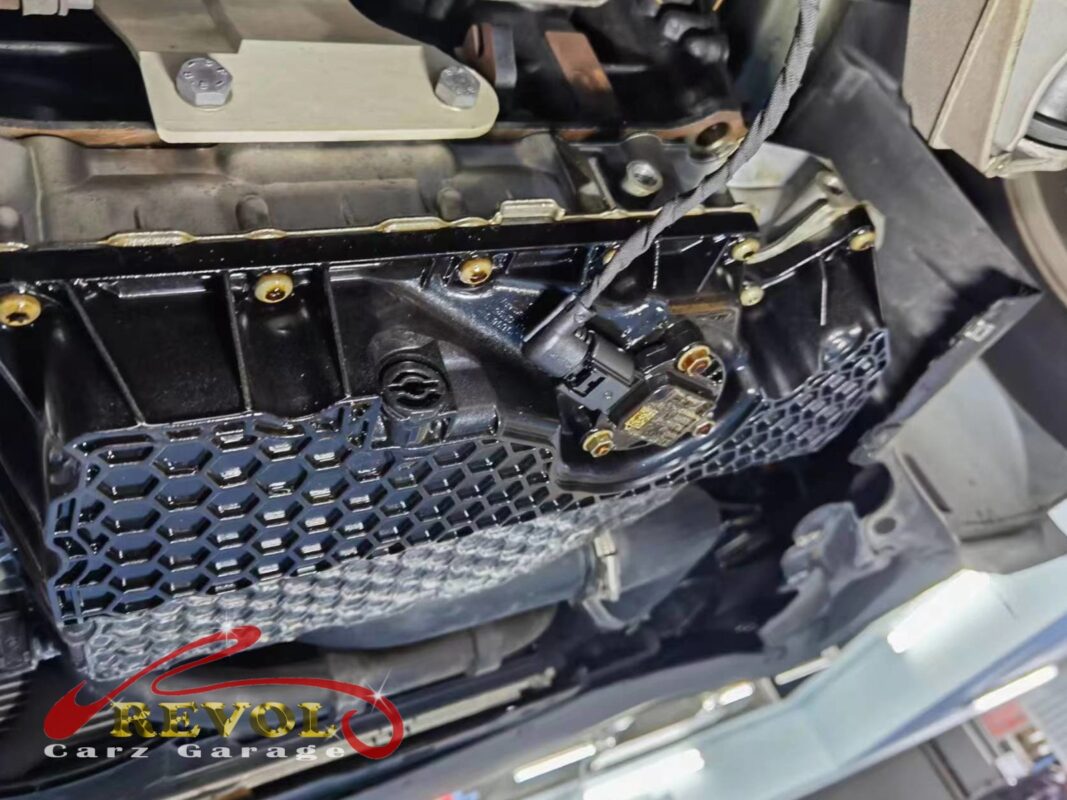 The lower sump and the oil level sensor exposed under the car.