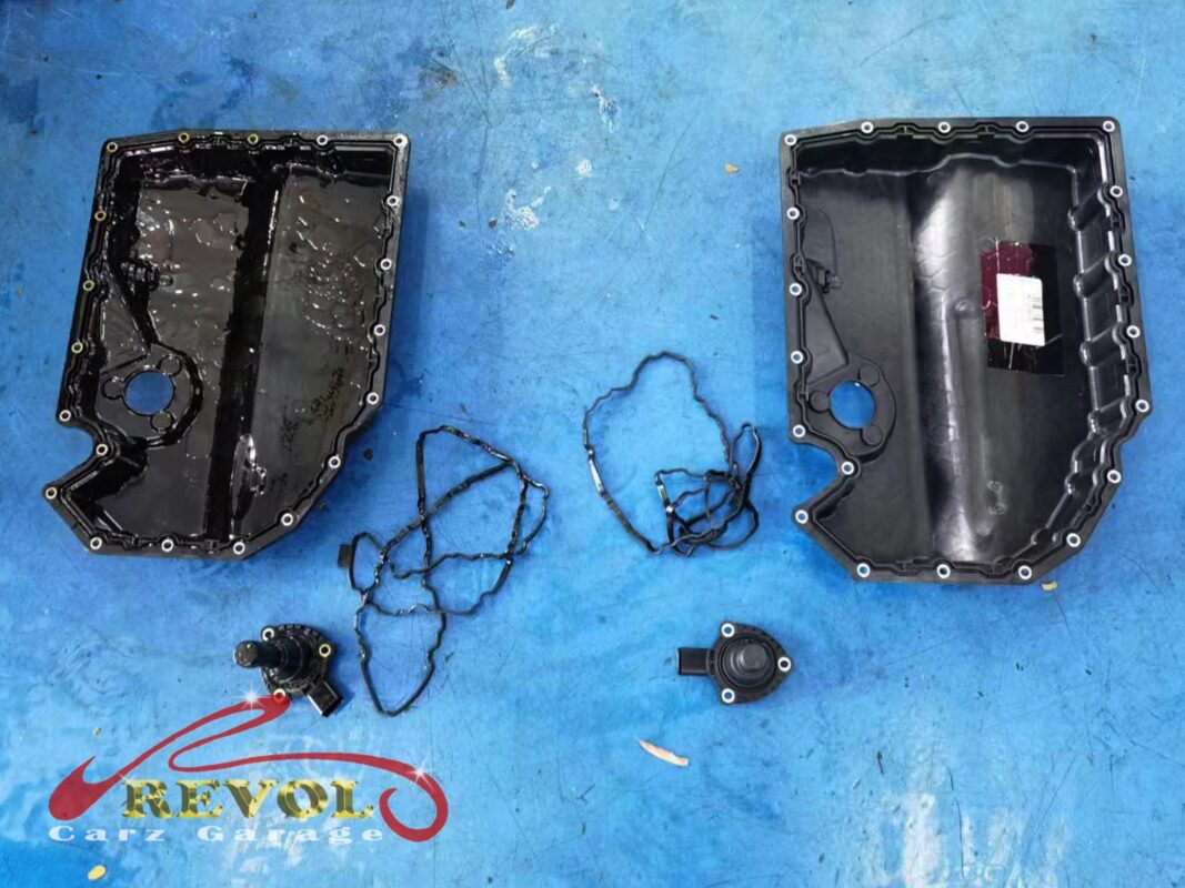 The old lower sump pan, gasket and oil level sensor (left) beside the new VAG-spec set (right).