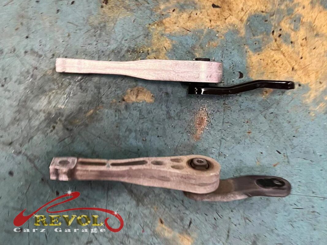 The old lower torque link (bottom) beside the new VAG-spec replacement (top).