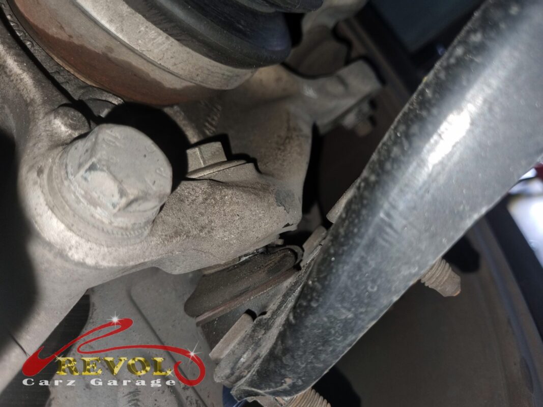 The lower control arm and ball joint at the knuckle, before the swap.