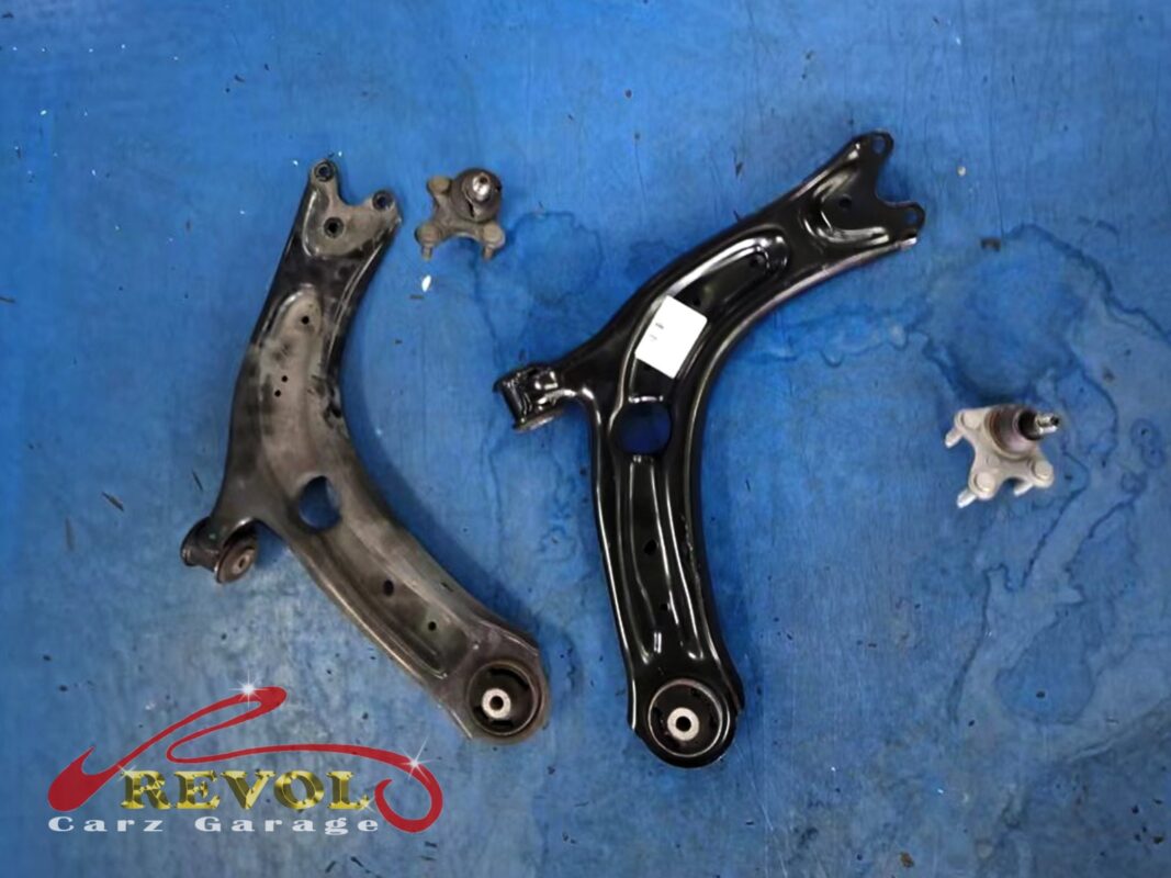 The old lower arm and ball joint (left) beside the new VAG-spec arm and ball joint (right).
