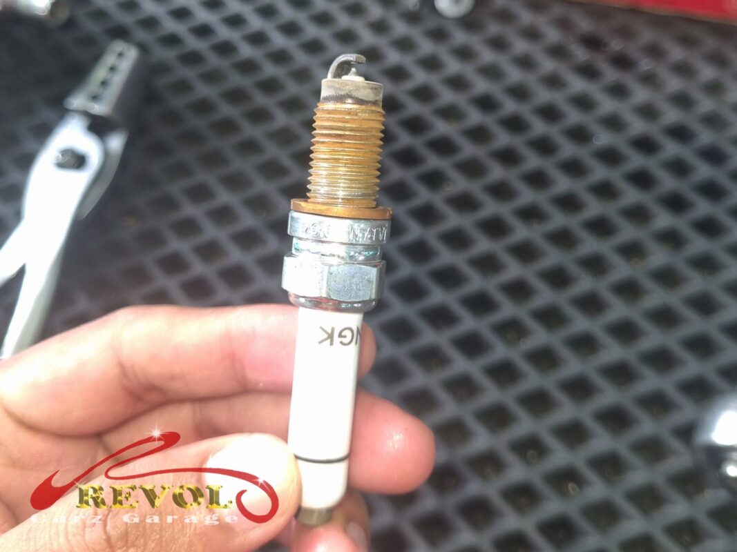 One of the old spark plugs out, the threads rusted and the tip worn down.