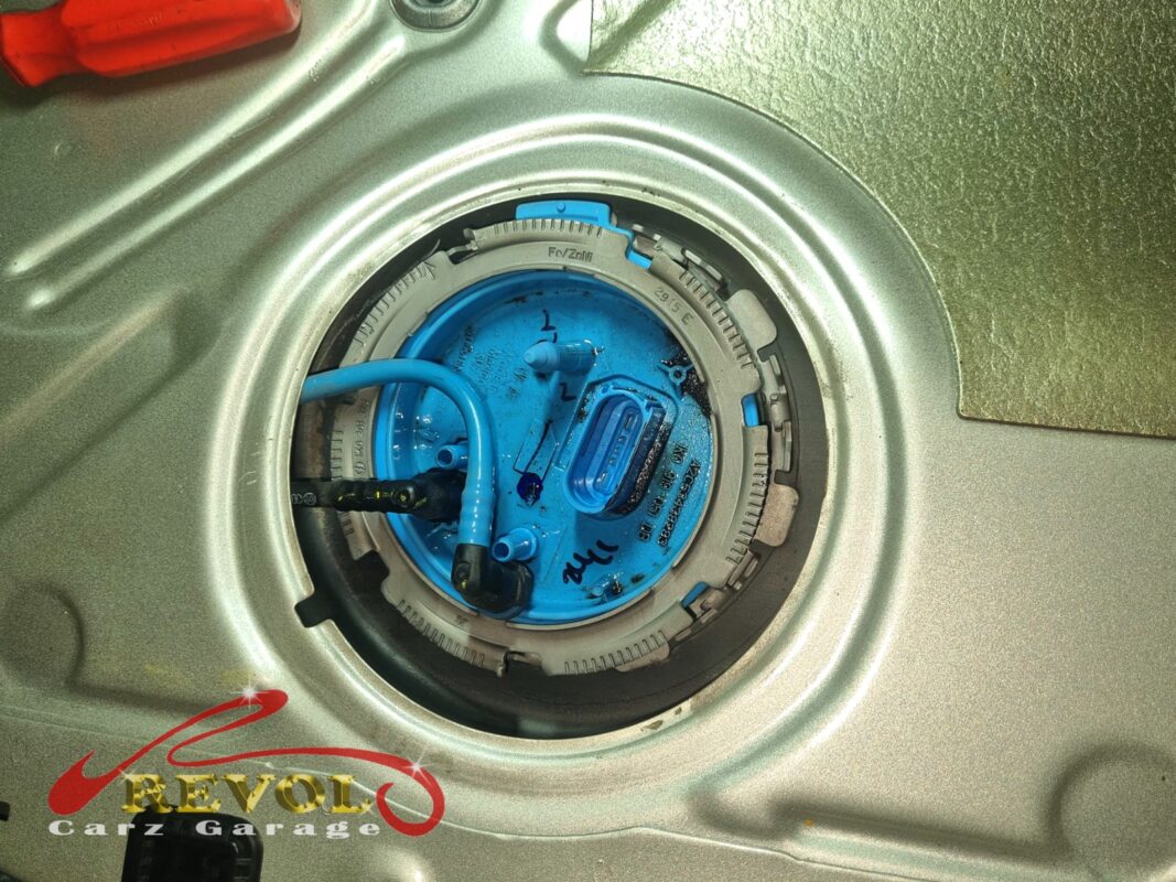 The in-tank fuel pump module exposed through the access hatch under the rear seat.
