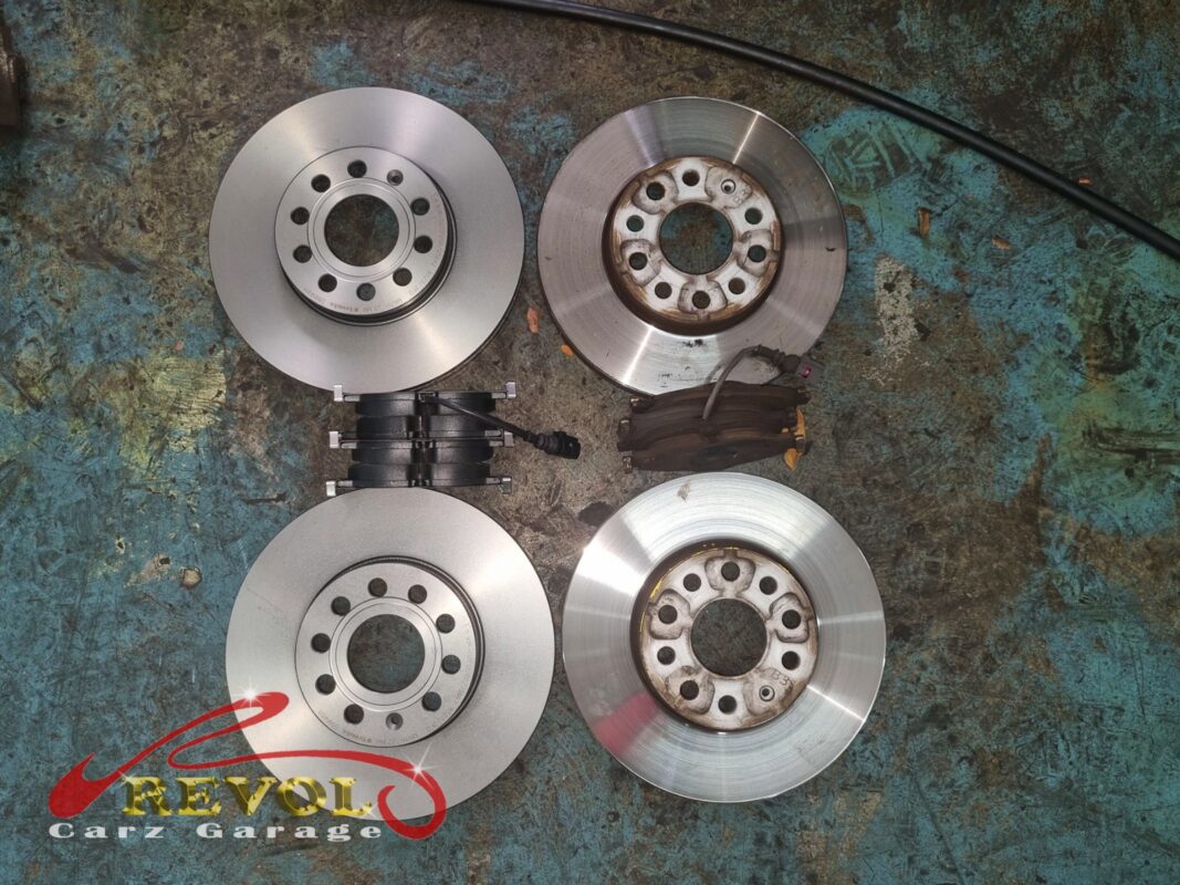 The full set side by side: new VAG-spec discs and pads against the worn parts that came off.