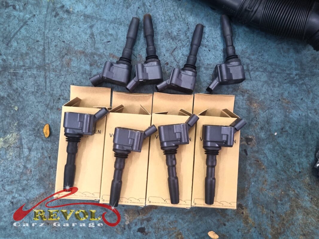 The four new VW ignition coils in their boxes (below) beside the four old coils that came off (above).